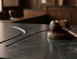 Mazo de juez sobre superficie de mármol que simboliza la toma de decisiones judiciales en casos de calumnia e injuria.
